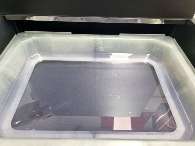 Beschädigte FEP-Folie mit sichtbaren Spuren in der Materialwanne