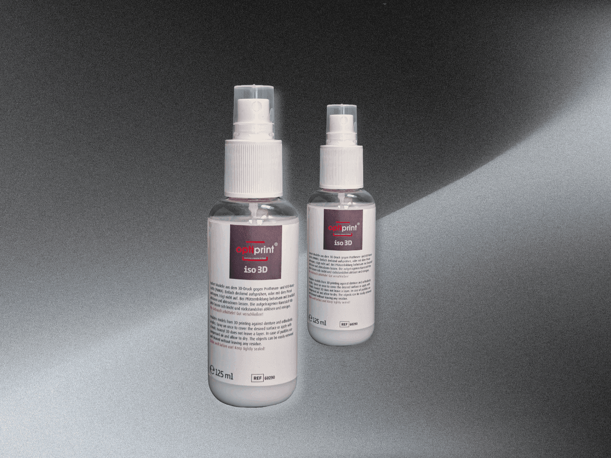Sprühflasche für Modellisolierung neben gedruckten Dentalmodellen
